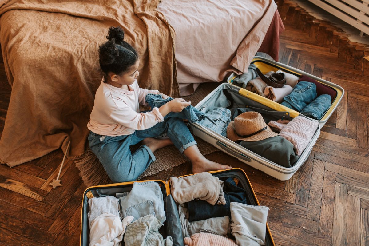 A kid packing a bag with essentials for summer