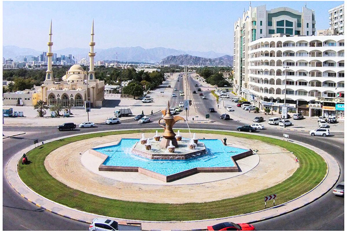 A roundabout road in Fujairah, recommended place for road trip in the UAE, showing the view of the city with mosque and buildings