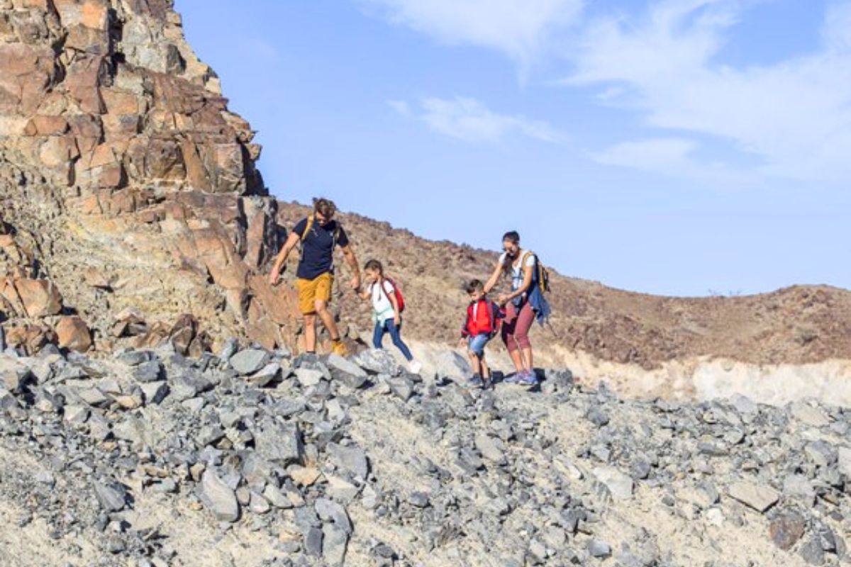 A family climbing up a mountain in Kalba Sharjah on a road trip in the UAE