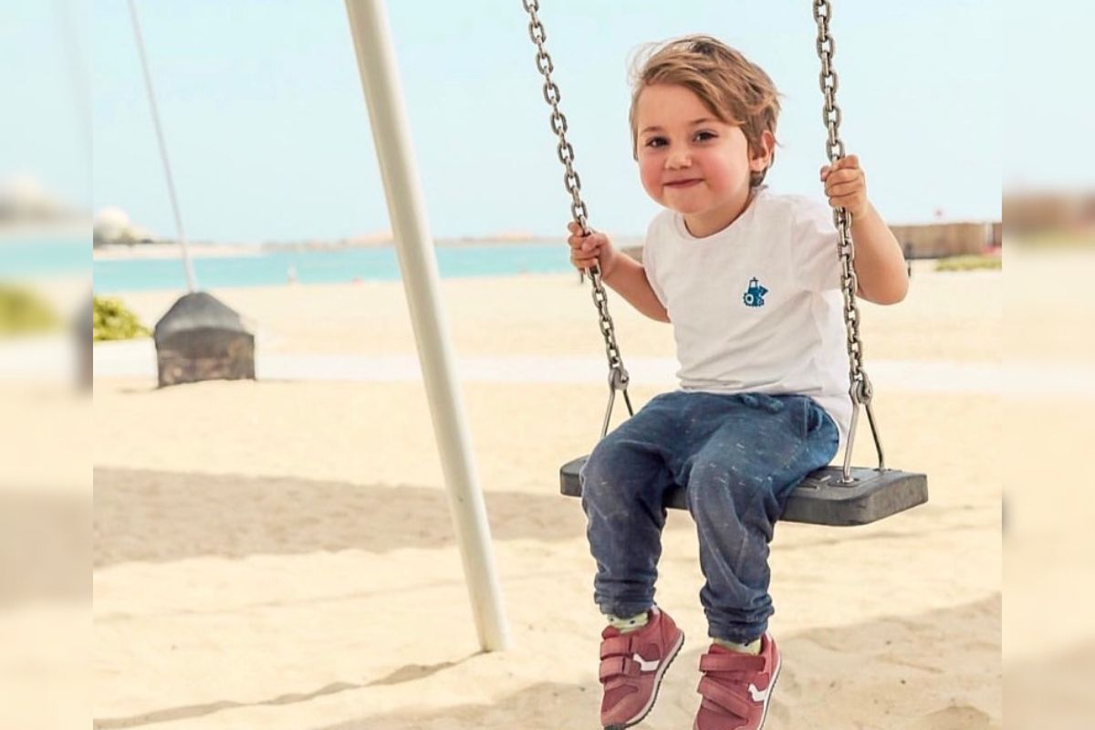 A kid swinging on a beach at A'l Bahar beach in Abu Dhabi