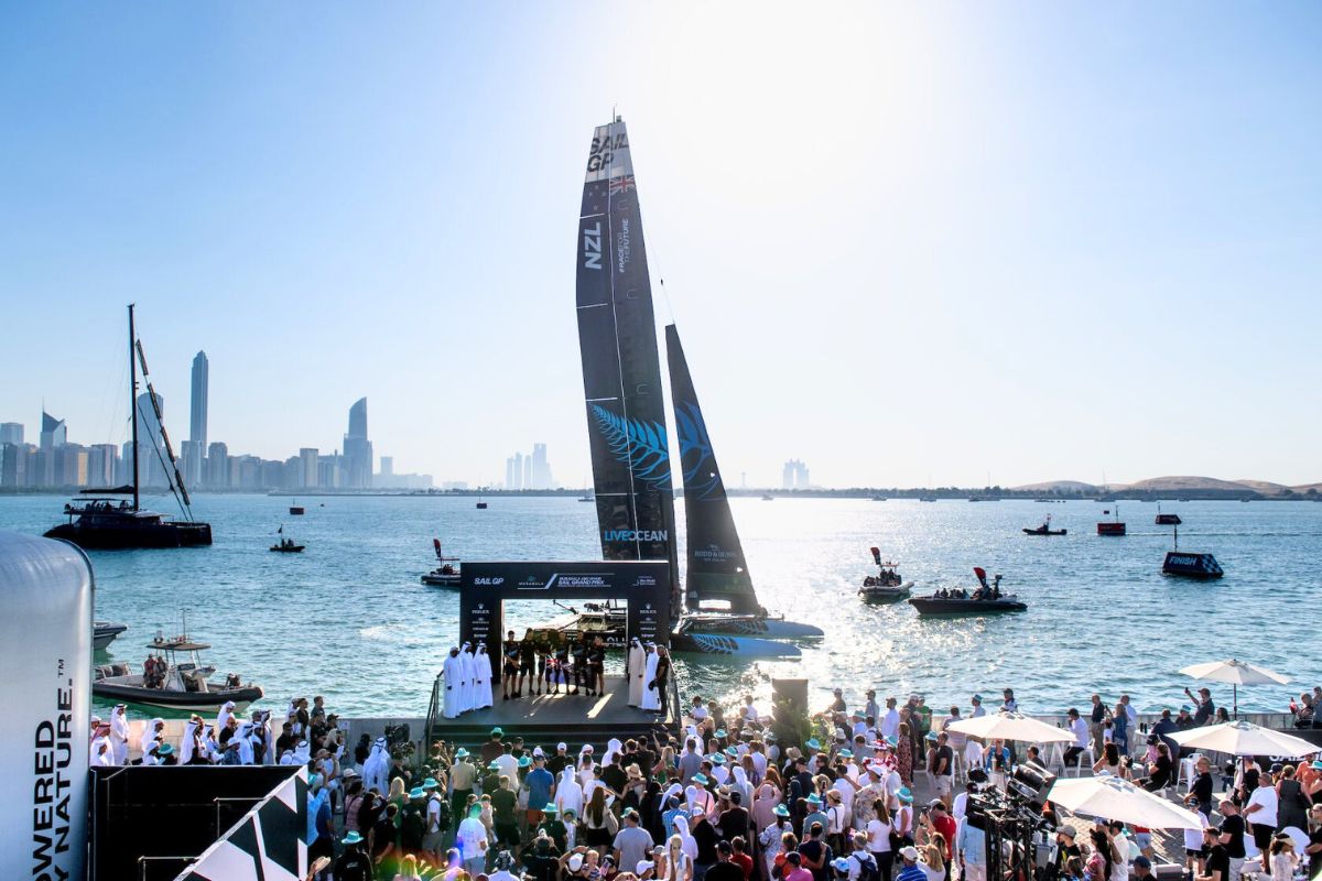 SailGP, SailGP 2024, Abu Dhabi Sail Grand Prix, Abu Dhabi Sail Grand Prix 2024, Image3-Peter Burling, Co-CEO and driver of New Zealand SailGP Team celebrates with the trophy on the podium, Image2-New Zealand SailGP Team helmed by Peter Burling celebrate victory in front of the SailGP Race Stadium, Image1-Aerial view of the SailGP F50 catamaran fleet passsing the SailGP Race Stadium on Race Day 2 of the Mubadala Abu Dhabi Sail Grand Prix presented by Abu Dhabi Sports Council, abu dhabi sports council, abu dhabi sports council 2024, mubadala, mubadala sports 2024, mubadala 2024