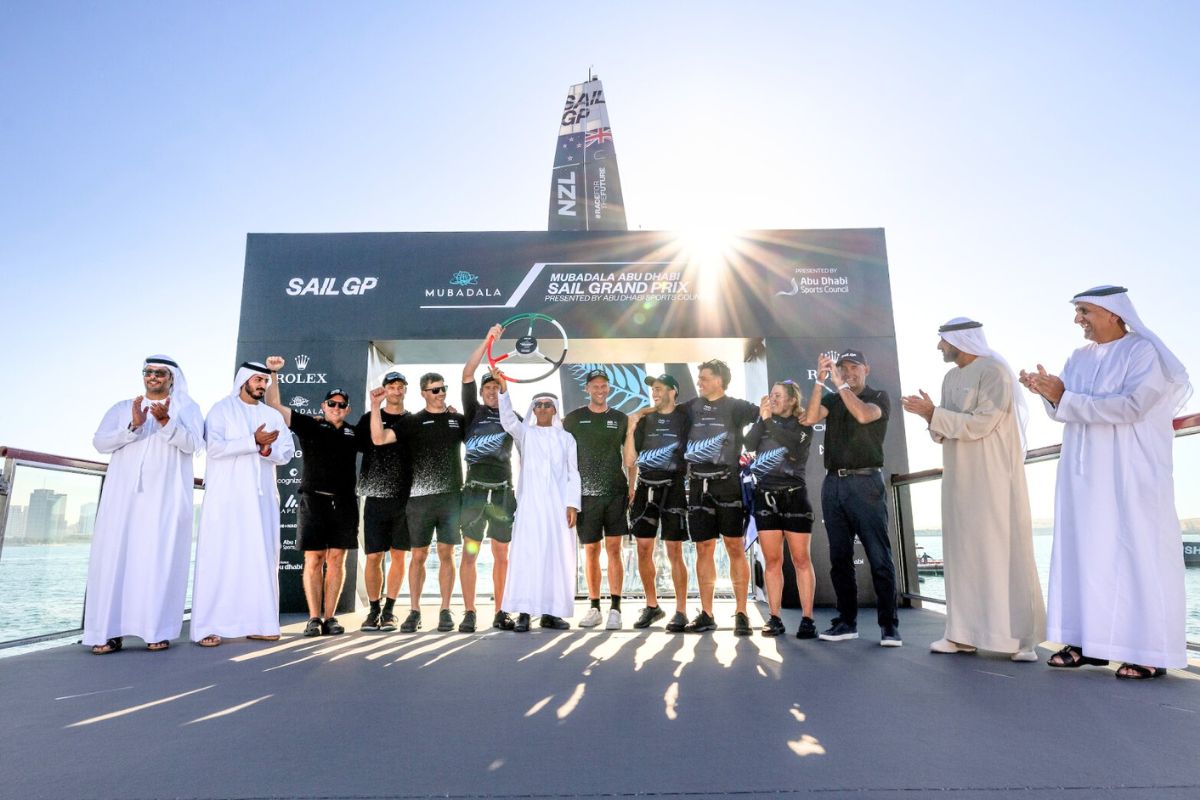 SailGP, SailGP 2024, Abu Dhabi Sail Grand Prix, Abu Dhabi Sail Grand Prix 2024, Image3-Peter Burling, Co-CEO and driver of New Zealand SailGP Team celebrates with the trophy on the podium, Image2-New Zealand SailGP Team helmed by Peter Burling celebrate victory in front of the SailGP Race Stadium, Image1-Aerial view of the SailGP F50 catamaran fleet passsing the SailGP Race Stadium on Race Day 2 of the Mubadala Abu Dhabi Sail Grand Prix presented by Abu Dhabi Sports Council, abu dhabi sports council, abu dhabi sports council 2024, mubadala, mubadala sports 2024, mubadala 2024