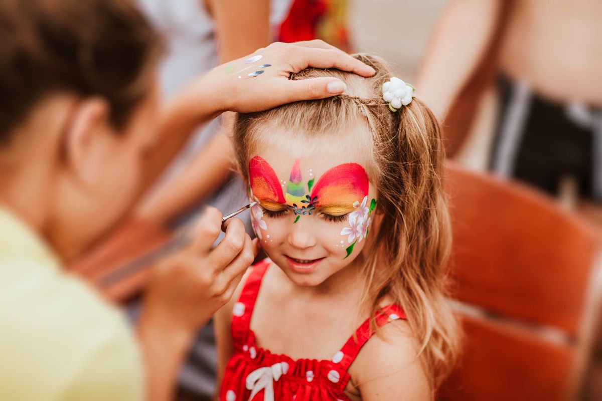 a little girl having her face painted at Yas Acres Golf and Country Club summer offers 2024