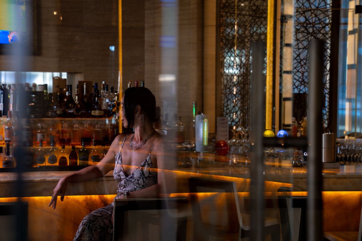 A lady sitting at the bar at Lexx Grand Hyatt Abu Dhabi for the best happy hours and sundowners 2024