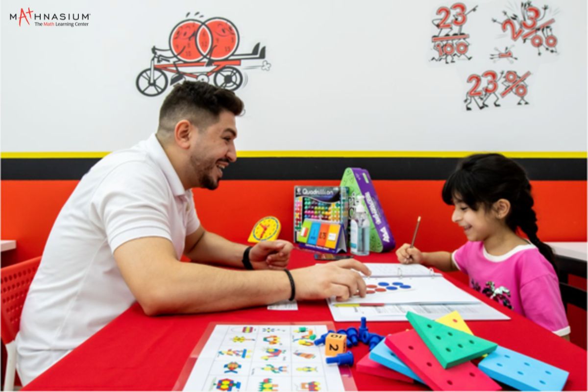 A tutor teaching math to a little girl at Camp Mathnasium summer camp