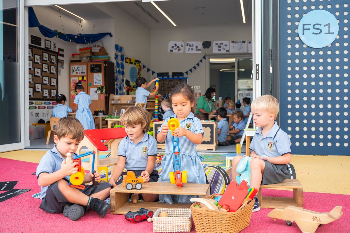 4 kids playing in the playground with toys at their back also busy kids playing at Cranleigh Abu Dhabi school