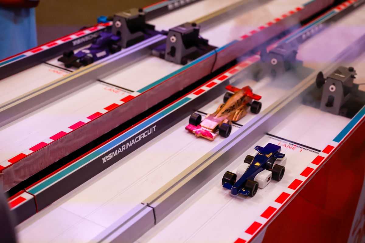 Toy cars racing on a track for Yas Marina Circuit School Competition