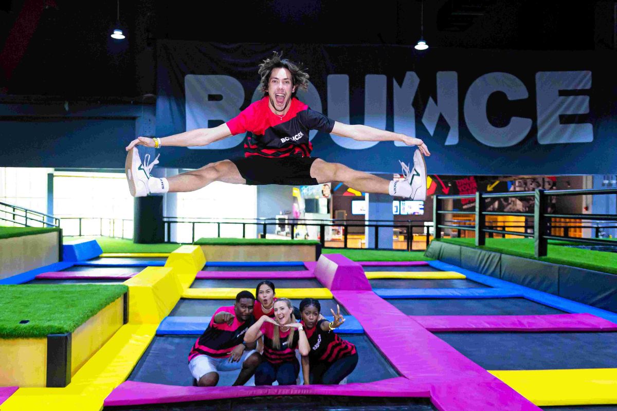 Man bouncing and doing split with people at Bounce