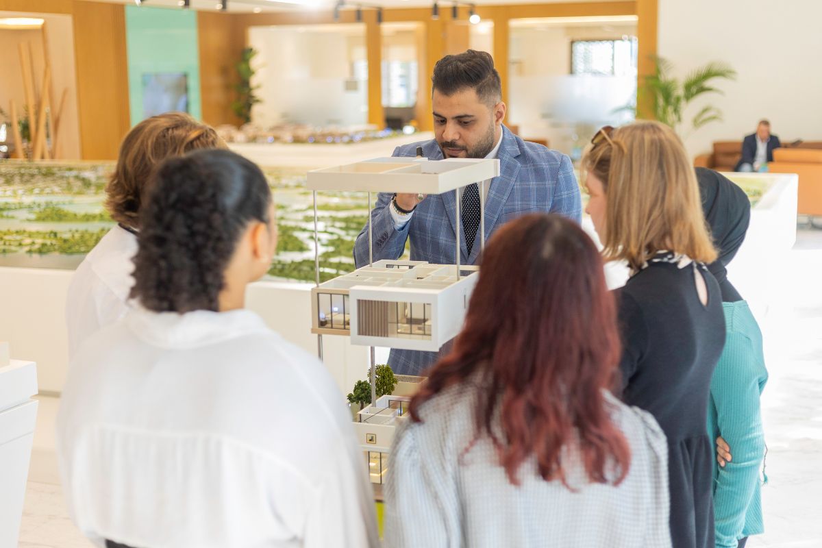 Cranleigh Abu Dhabi Senior School students with a teacher looking at a town house model