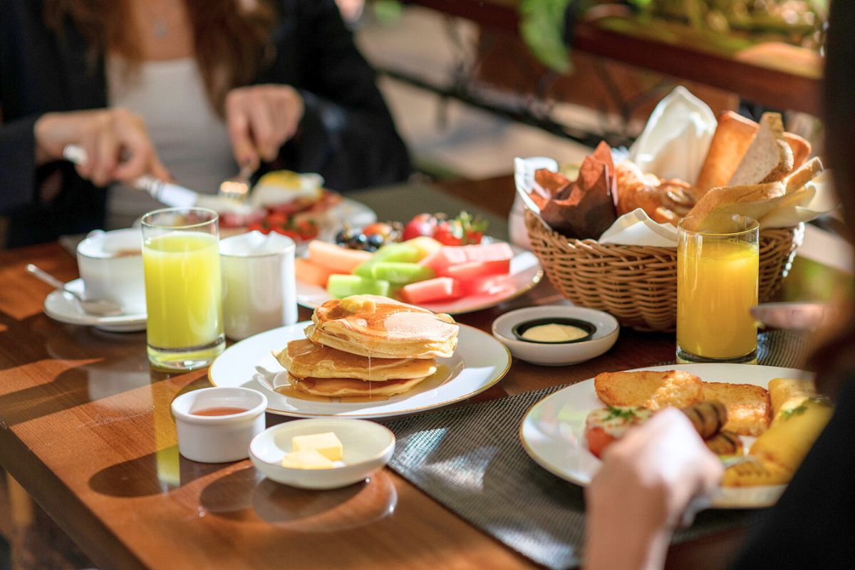 An array of amazing breakfast items such as pancakes, fruit juices, mixed fruit platters, bread and more at Giornotte The Ritz-Carlton Abu Dhabi Grand Canal for the best breakfast offerings in Abu Dhabi