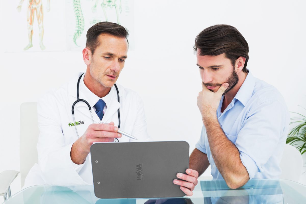 Howa Men's Health clinic, a doctor giving advise to a patient while showing a chart 