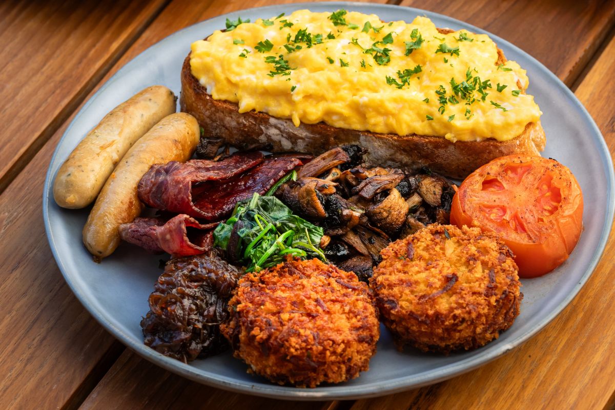 A great breakfast plate of Jones the Grocer full english breakfast version with grilled tomato, mushroom, sausage, toast with scrambled egg for the best breakfast offers in Abu Dhabi