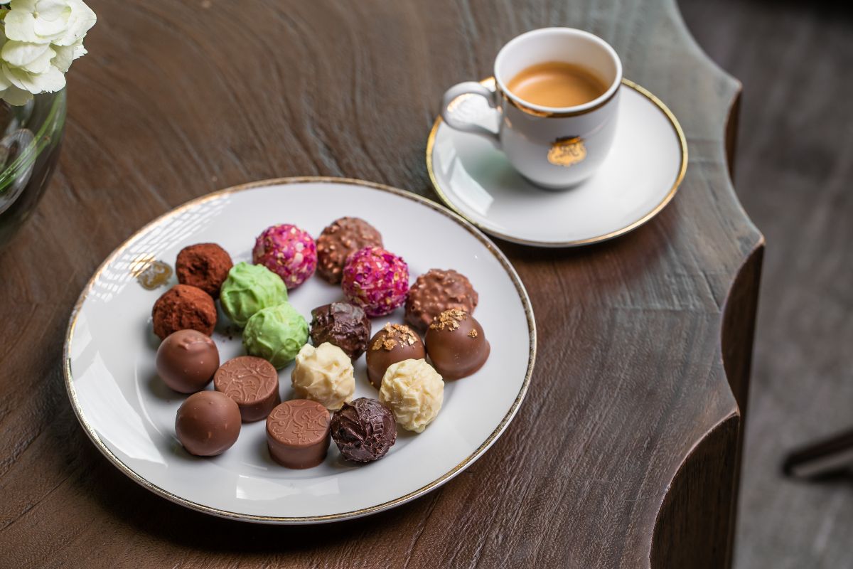 Different types of chocolates and coffee in the table at Drawing Room at The St. Regis Saadiyat Island Resort Abu Dhabi