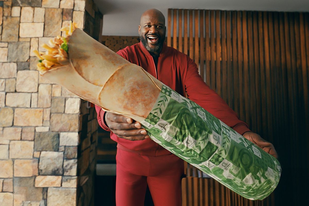 Shaq O'Neil holding a big shawarma in Abu Dhabi