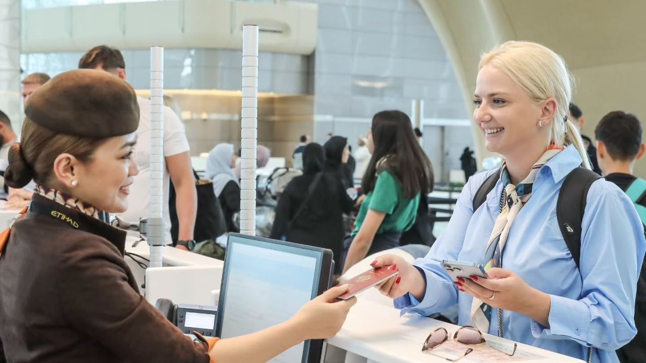 abu dhabi airport passenger checking in her luggage and documents