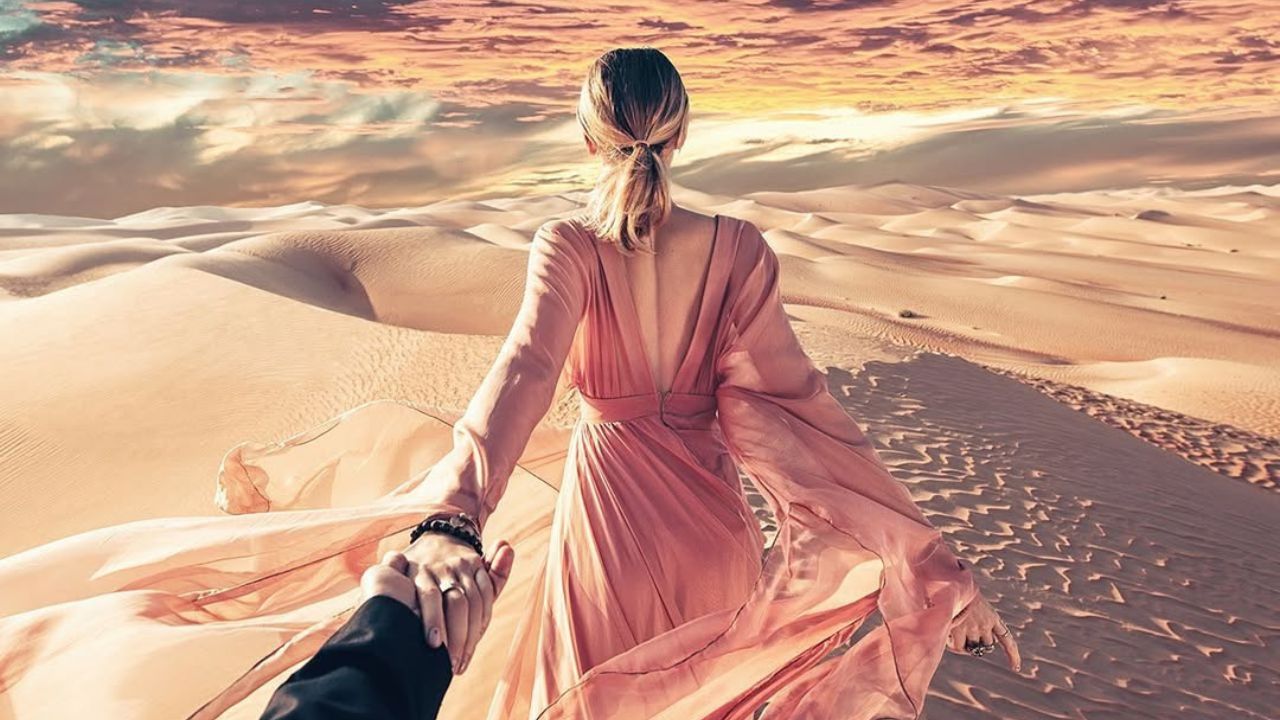 girl walking through the desert with her partner