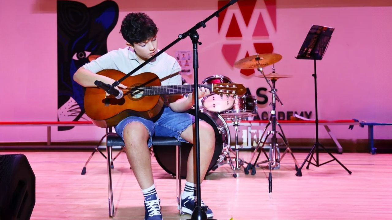 the music hub abu dhabi student playing guitar