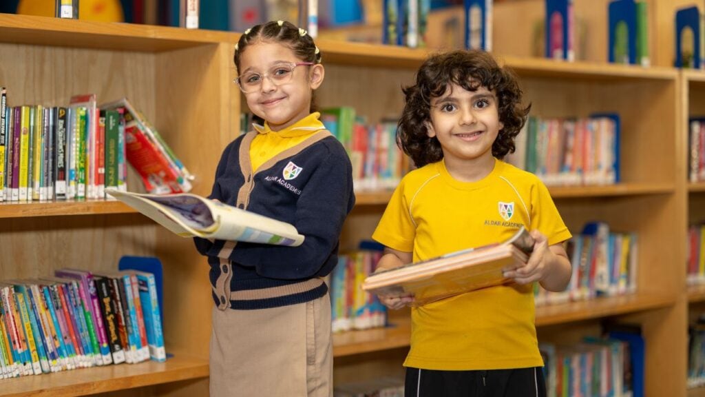 muna british school kids in a library smiling holding books