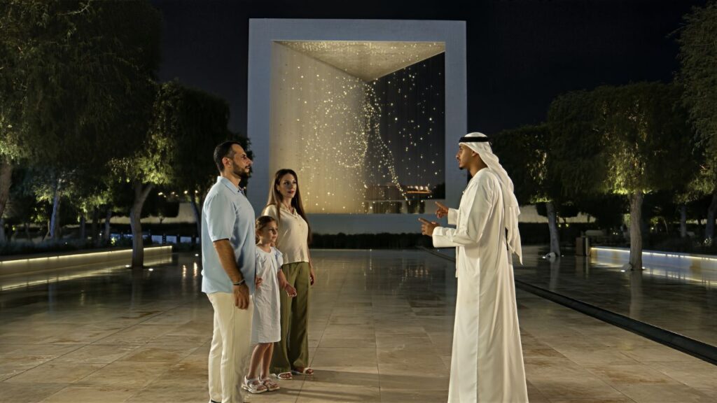 A family with an Arabic guide in front of a tourist spot in Abu Dhabi