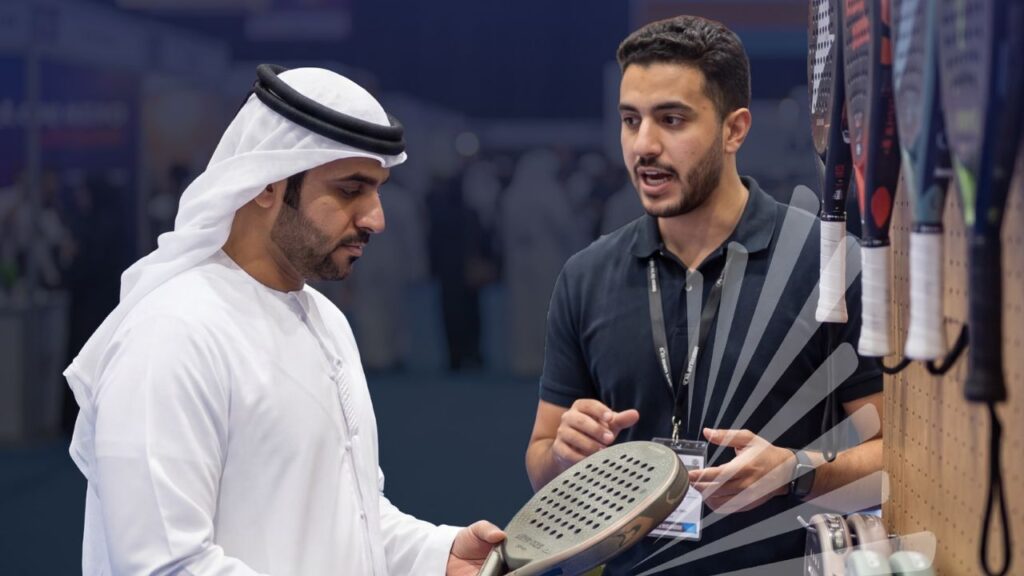 man wearing kandura looking at a tennis racket