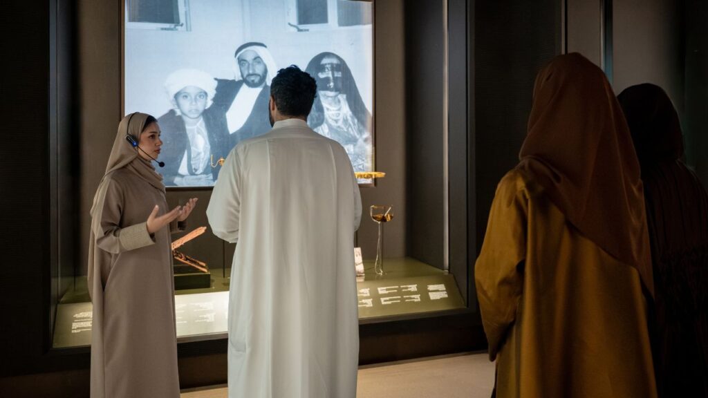 Zayed National Museum show - a guide explaining a slide to audience