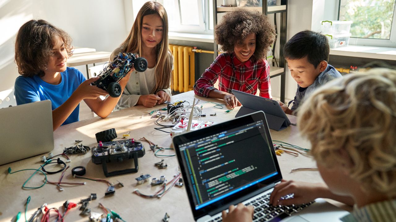 Diverse School Children Students Build Robotic Cars Using Computers and Coding.