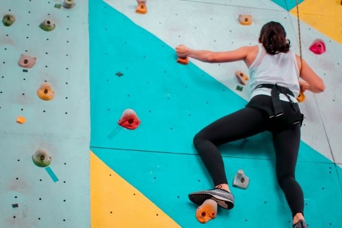 Girl climbing a wall at West Bay adventure park