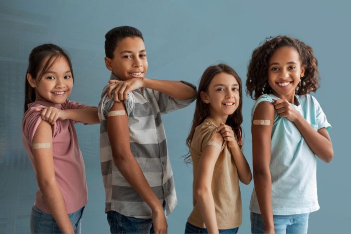 free mmr vaccine in abu dhabi, children showing their vaccinated arms