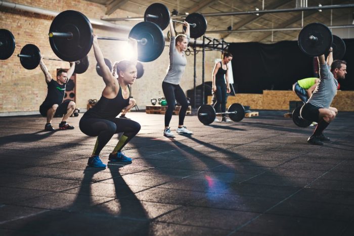 People lifting weights at the gym for a healthier lifestyle as advised by the obesity doctor from UE Medical Healthplus