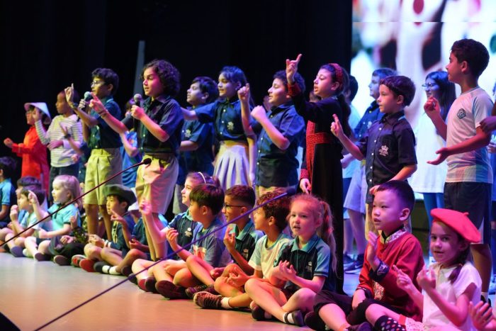 Students lined up sitting and standing on stage at Nord Anglia International School Abu Dhabi for World Languages Day