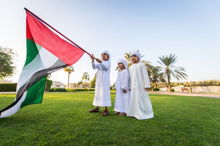 UAE Emirati kids holding a UAE flag