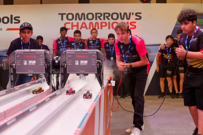 Students racing with toy cars at Yas Marina Circuit school competitions