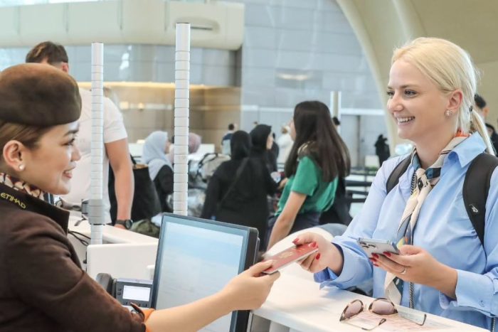 abu dhabi airport passenger checking in her luggage and documents