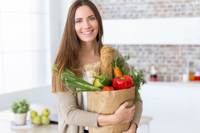 beautiful-young-woman-with-vegetables-grocery-bag-home_1301-7672